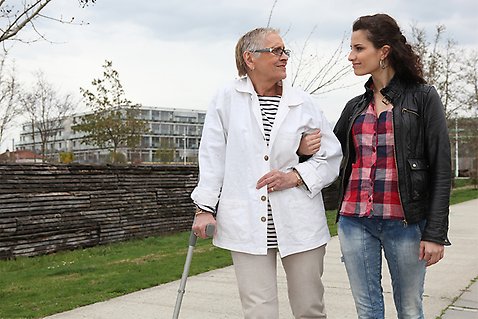 Äldre kvinna och ung kvinna på promenad utomhus. 