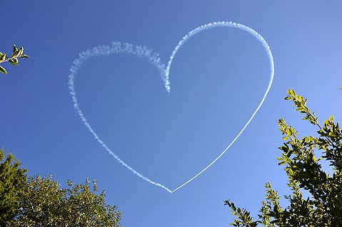 Hjärta av moln eller flygplan på himlen.