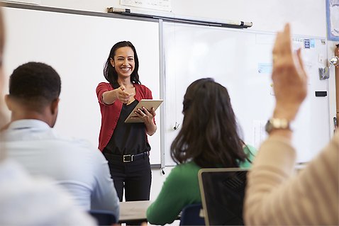 En lärare undervisar vuxna elever i ett klassrum.
